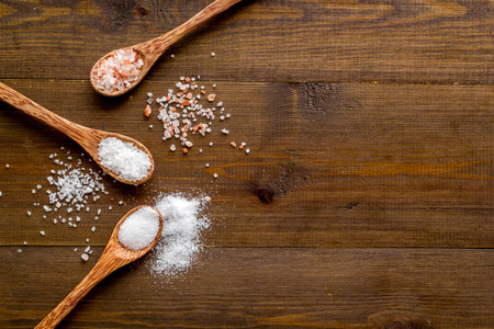 Different kind of sea salt in wooden spoon, top view. Salt for spa, salt baths or cooking.の写真素材