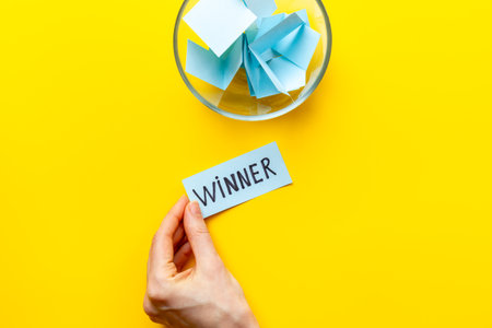 Hand is picking a winner ticket from glass jar, top view. Luck and lottery conceptの写真素材