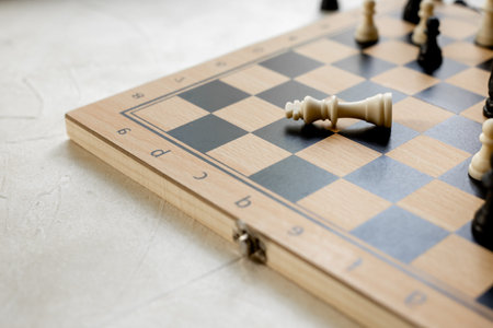 Checkmate. White king chess piece laying down on chessboard after checkmate.