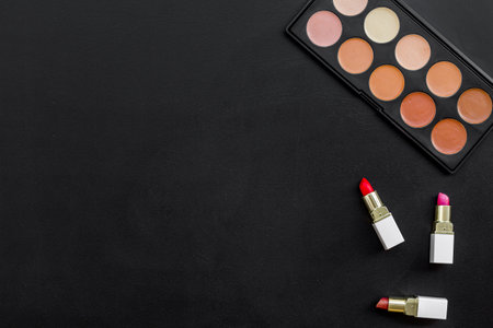 Flatlay of makeup cosmetics on black table. Blusher, mascara and lipstick, top view.の写真素材