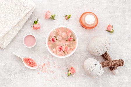 Roses essence water in bowl with petals and skin care cosmetic products with flowers essential oil.の写真素材