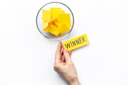 Hand is picking a winner ticket from glass jar, top view. Luck and lottery conceptの写真素材