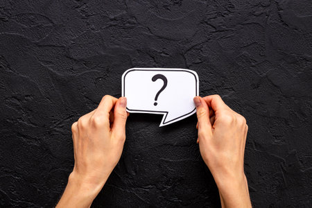 Hands are holding Question mark speech bubbles top view. FAQ concept.