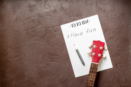 Small guitar ukulele on To do list with words Have fun. Musical instruments, top viewの写真素材
