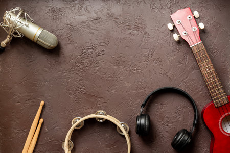 Musical instruments for band - small guitar, drumsticks and tambourine with studio microphone. Recording music in a studioの写真素材
