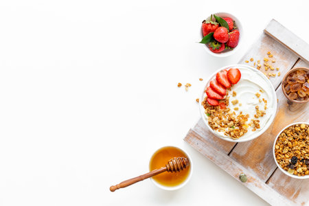 Bowl with yogurt and oatmeal served with honey and strawberry, top view.の写真素材