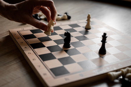 White and black chess pieces on chessboard during the game, close up.の写真素材