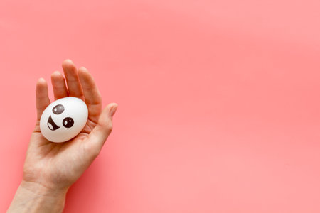 Positive emotion concept. Hand holds egg with facial expressions. Communication and comments on social networks.の写真素材