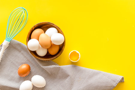 Chicken eggs in wooden bowl on cooking table, top view. Food pattern. Easter background.の写真素材