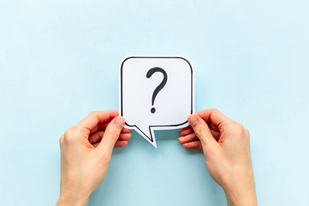 Hands are holding Question mark speech bubbles top view. FAQ concept.の写真素材