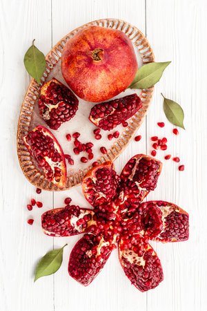Top view of fresh ripe pomegranate and pieces on plate for eating, top viewの写真素材