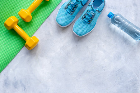 Flat lay of fitness sports equipment. Sneakers and dumbbells for gym. Wellness concept.の写真素材