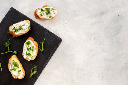 Healthy snack - sandwiches with microgreens on stone board, top view.の写真素材