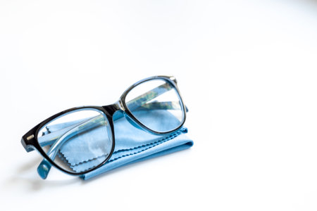 Stylish eyeglasses with glasses cloth on white. Eye care and protection concept.の写真素材