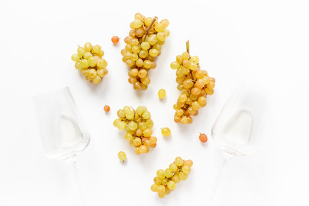 Two glasses of white wine and yellow grapes brunches, top view.の写真素材