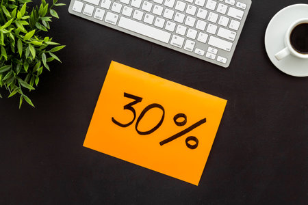 Sales and online shopping concept. Top view of a table with computer and discount percentage sing.