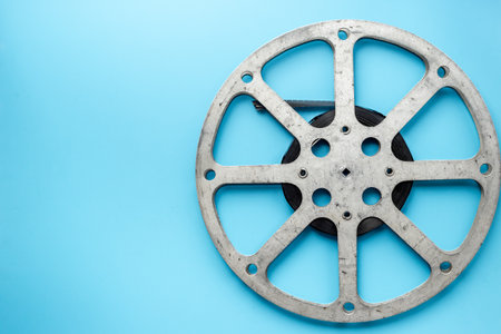 Old 35mm motion picture film reel on blue background. Cinema concept.の写真素材