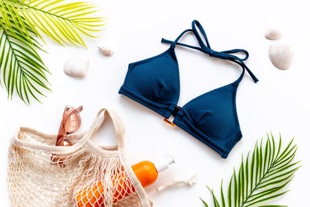 Bikini swimsuit with and palm leaves with beach accessories. Flat lay, top view.の写真素材
