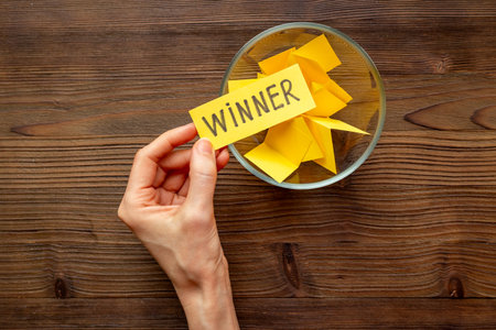 Hand is picking a winner ticket from glass jar, top view. Luck and lottery conceptの写真素材