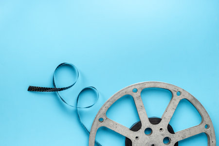 Old 35mm motion picture film reel on blue background. Cinema concept.の写真素材