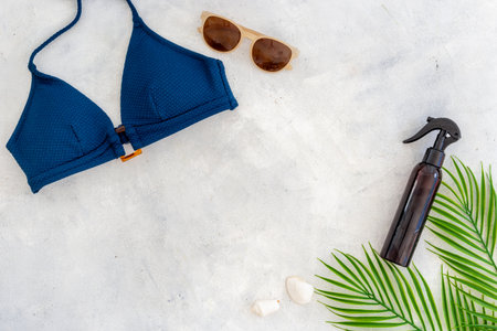 Bikini swimsuit with and palm leaves with beach accessories. Flat lay, top view.の写真素材