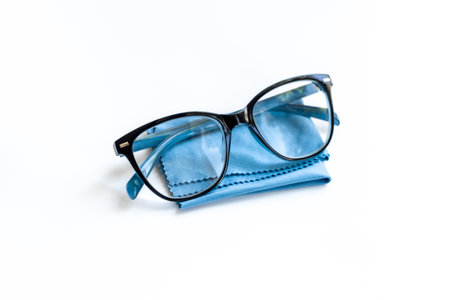 Stylish eyeglasses with glasses cloth on white. Eye care and protection concept.の写真素材