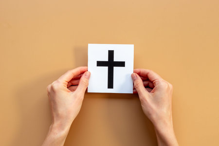 Hands holding Christianity cross symbol. World religious concept.の写真素材