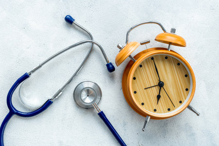 Stethoscope and vintage alarm clock, top view. Time for medical checkup.の写真素材