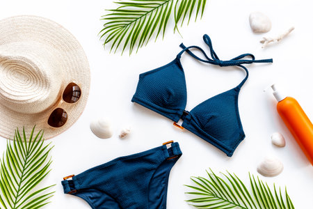 Bikini swimsuit with and palm leaves with beach accessories. Flat lay, top viewの写真素材
