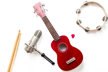 Musical instruments for band - small guitar, drumsticks and tambourine with studio microphone....