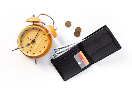 Black wallet with money cash bank card and alarm clock. Time to pay taxes or credit concept.