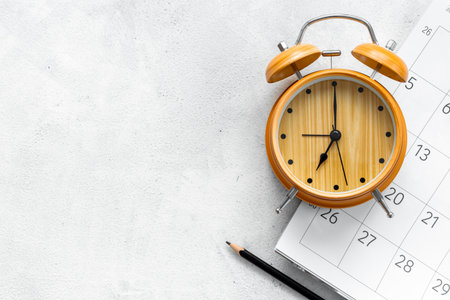 Alarm clock is on calendar with pencil, top view. Planning and time management concept.の写真素材