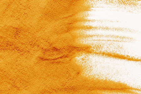 Frame of yellow sand texture on white background, close up top view. Abstract sand surface.