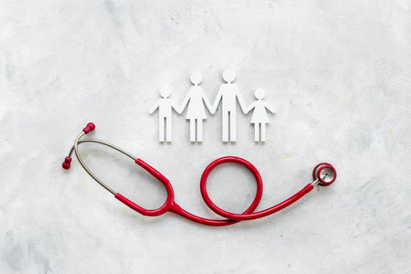 Family wooden figure with medical stethoscope - health care and insurance concept. top view.の写真素材