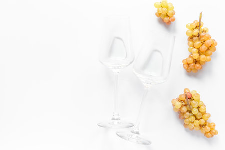 Two empty wine glasses with ripe yellow grapes, top view.の写真素材