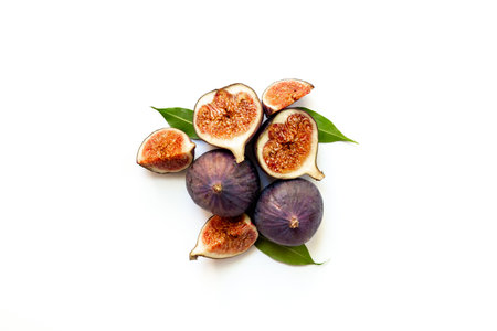 Purple ripe figs fruit and slices with green leaves top view on a white background.の写真素材