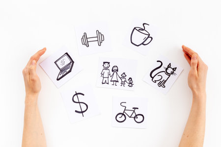 Hands with many paper cards with hand drawing of different life activities, top view. Time management concept. Life balance and planning conceptの写真素材