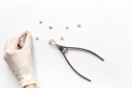Dentist hand in white medical glove is holding dental equipment tools for teeth care on white...
