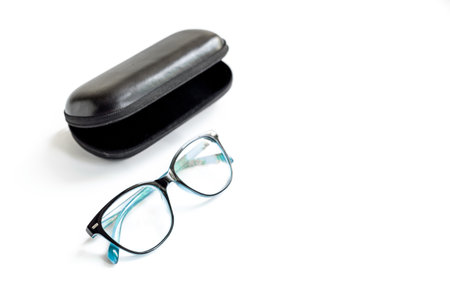 Stylish eyeglasses with glasses case on white. Eye care and protection concept.
