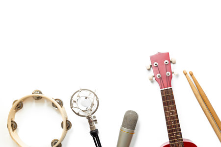 Musical instruments for band - small guitar, drumsticks and tambourine with studio microphone. Recording music in a studio.の写真素材