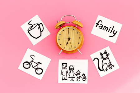 Retro alarm clock and many paper cards with hand drawing of different life activities, top view....