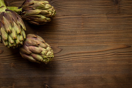 Whole heads of purple artichokes top view. Vegetables ready to cook.の写真素材