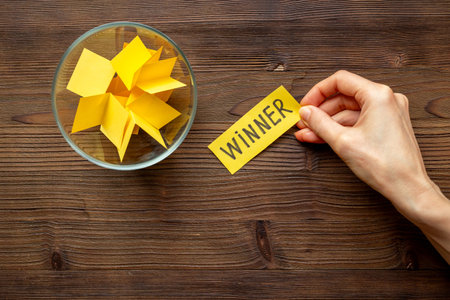 Hand is picking a winner ticket from glass jar, top view. Luck and lottery conceptの写真素材