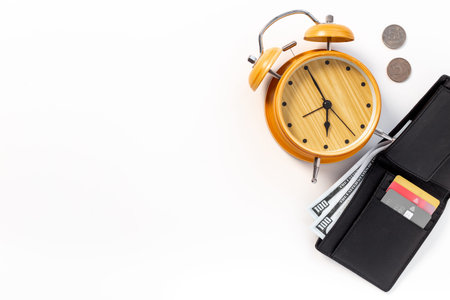 Black wallet with money cash bank card and alarm clock. Time to pay taxes or credit concept.