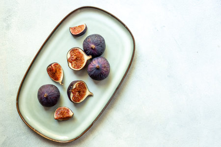 Fresh ripe figs on a plate top view on a gray background.の写真素材