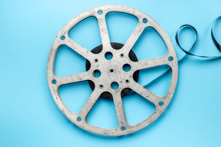 Old 35mm motion picture film reel on blue background. Cinema concept.の写真素材