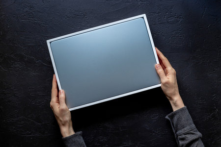 Top view of hands unpacking new silver laptop from a boxの写真素材