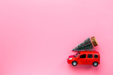 Red toy car with Christmas tree on the roof. Festive New Year conceptの写真素材