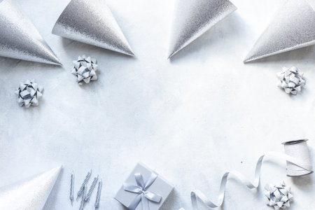 Festive party decoration in silver color with gift box and carnaval caps on gray stone background, top viewの写真素材