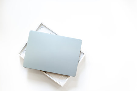 Silver laptop in a box on white desk top. Unpacking new gadget, top view.の写真素材
